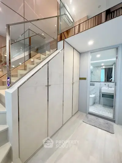 Modern duplex interior with sleek staircase and compact bathroom