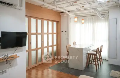 Modern open-plan living area with stylish bar counter and natural light.
