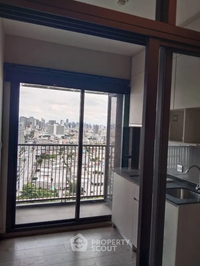 Modern apartment with city view from balcony and sleek kitchen design.