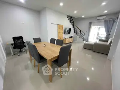 Spacious modern living room with dining area and sleek staircase