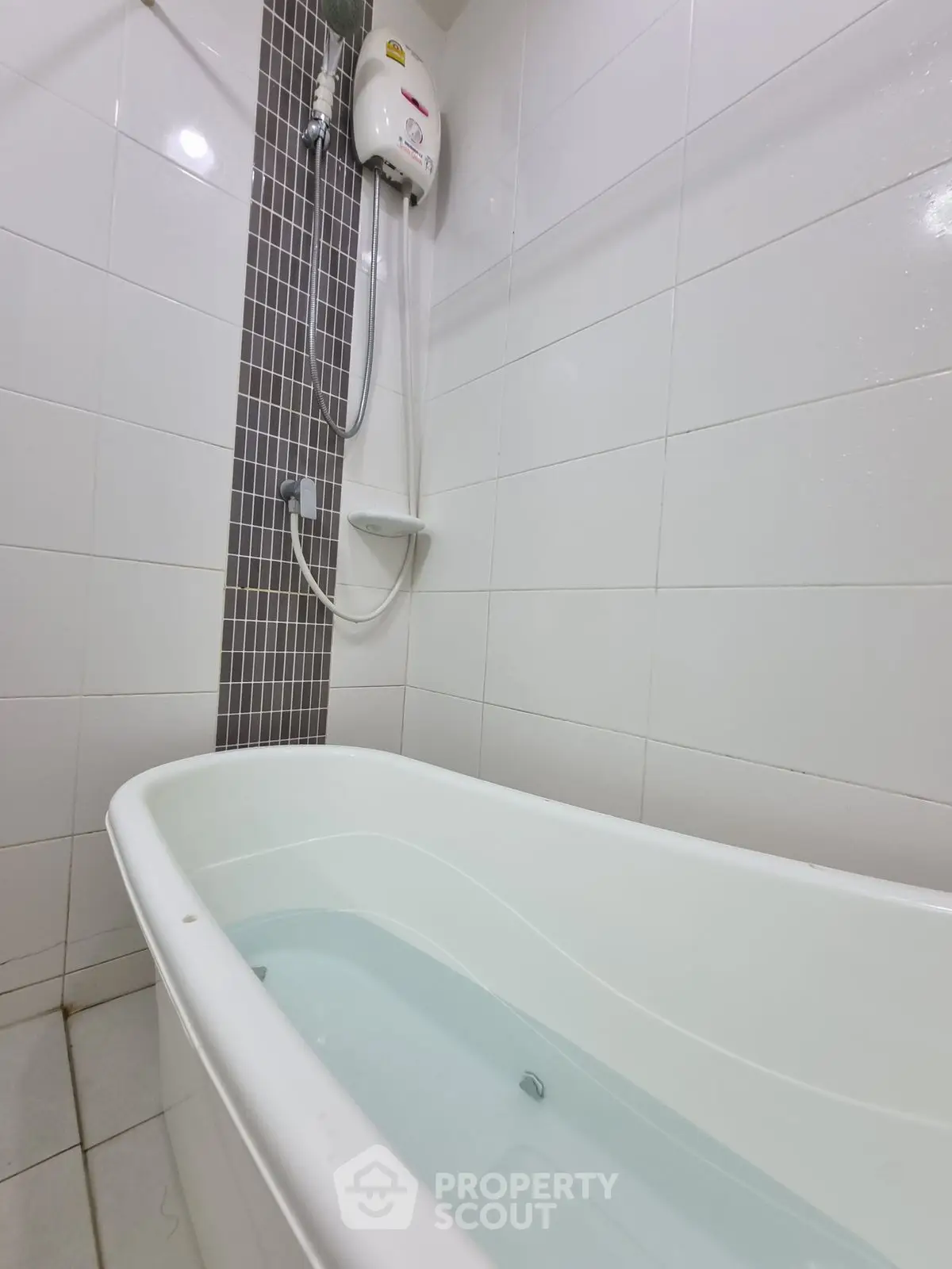 Modern bathroom with bathtub and shower in sleek white tile design.