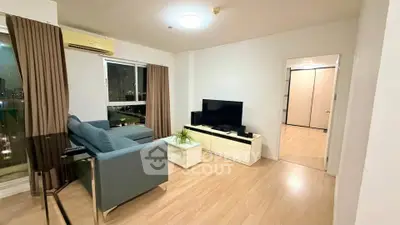 Spacious living room with modern furniture and city view, perfect for relaxation and entertainment.