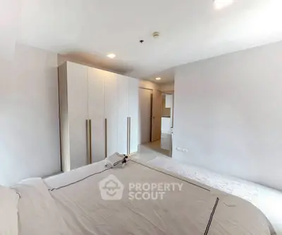 Modern minimalist bedroom with sleek wardrobe and cozy bedding