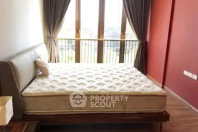 Spacious bedroom with large window and stylish decor