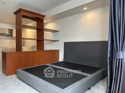 Spacious studio apartment with modern bed and open kitchen layout
