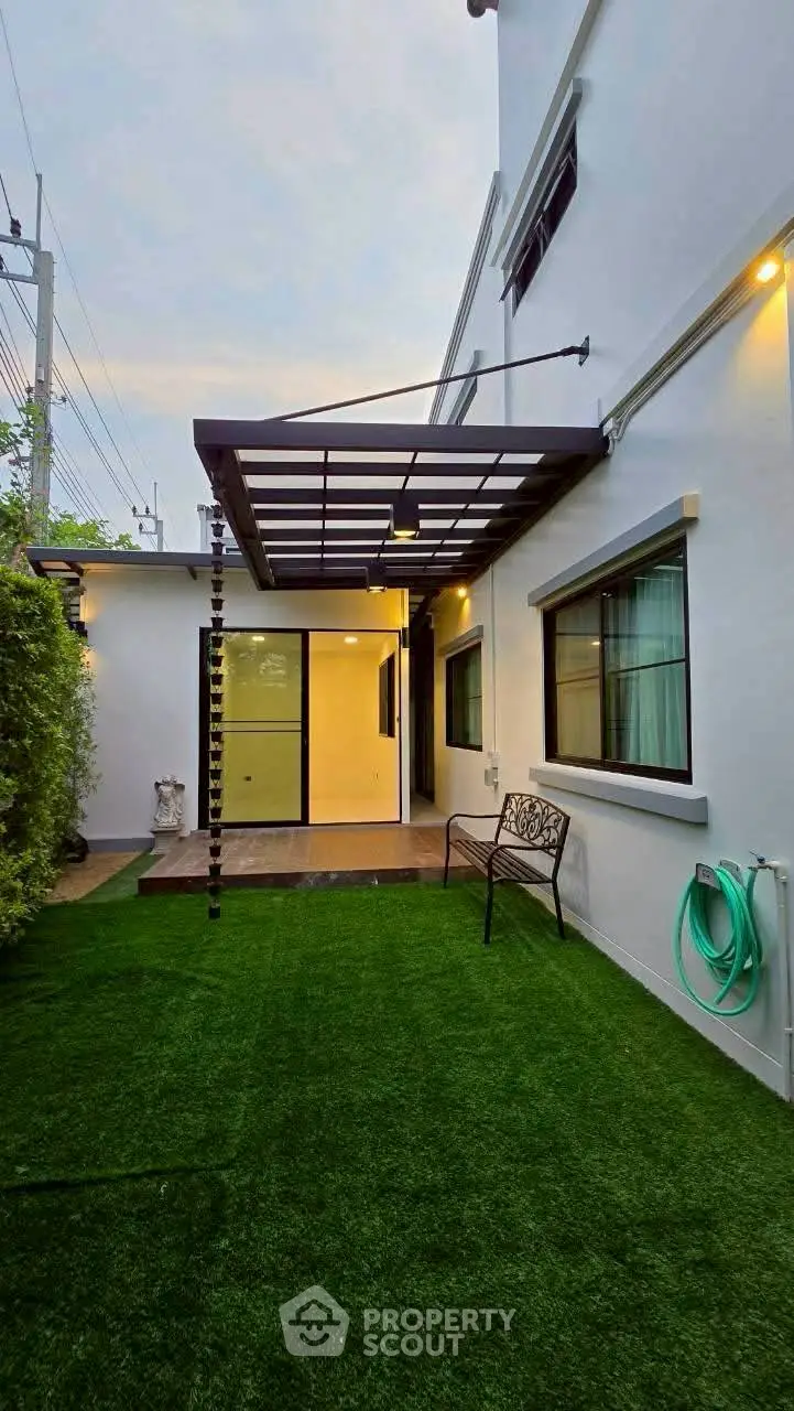 Charming backyard with artificial grass and modern pergola, perfect for outdoor relaxation.
