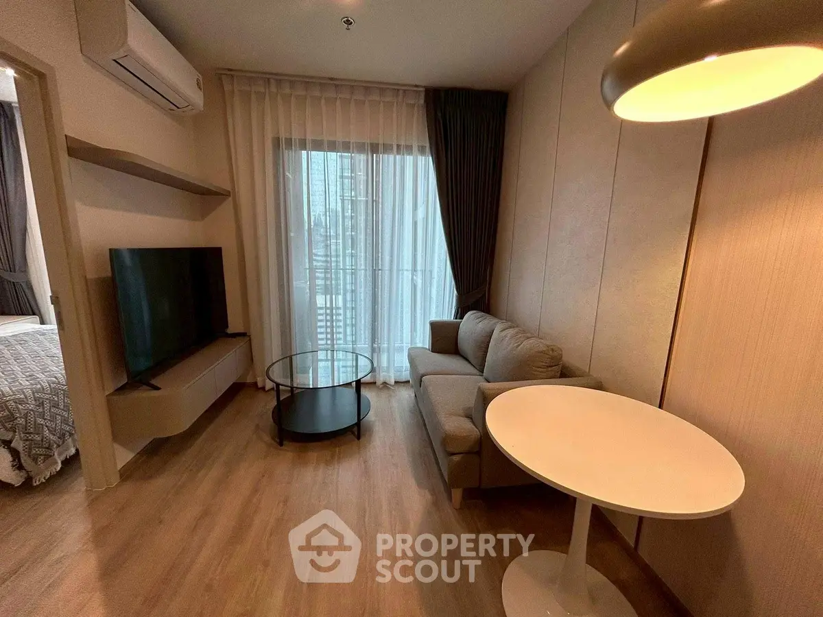 Modern living room with cozy sofa, TV, and stylish lighting in a contemporary apartment.