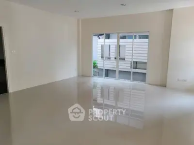 Spacious empty room with large windows and glossy tiled floor