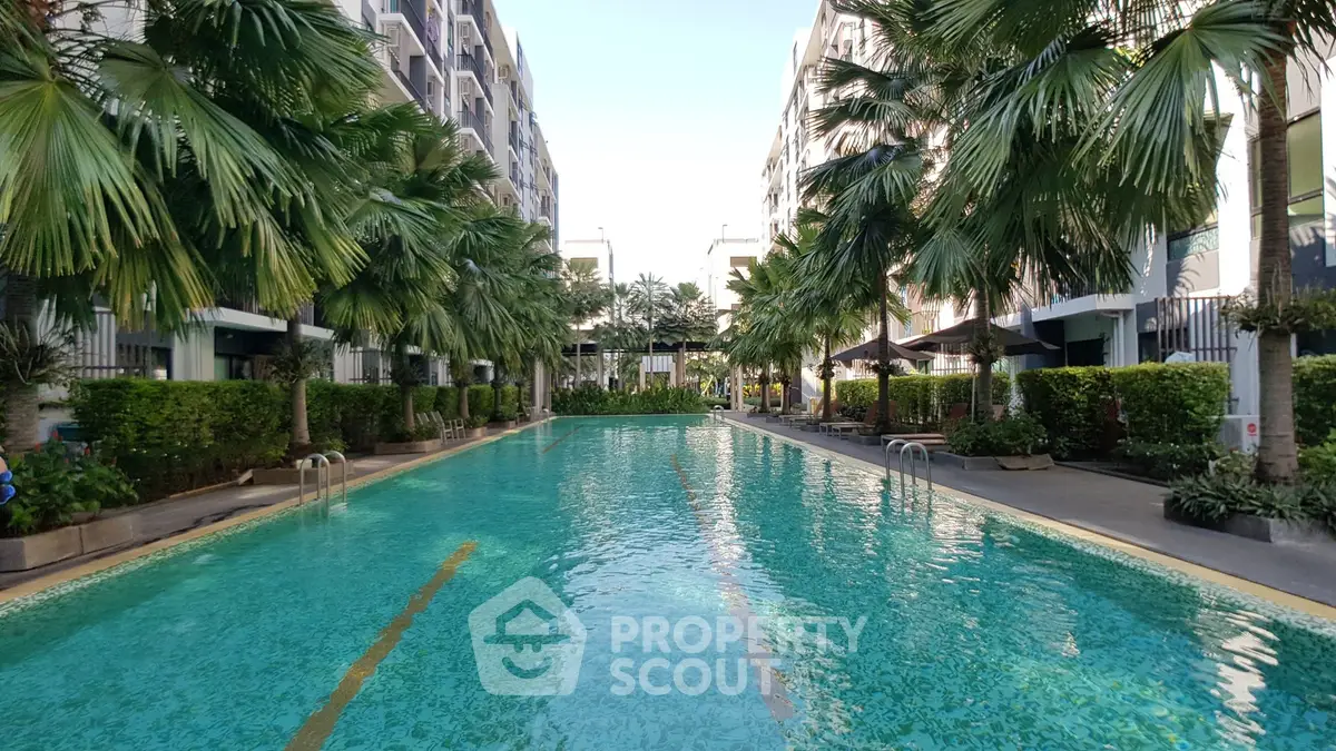 Luxurious residential pool surrounded by lush greenery and modern architecture, perfect for relaxation and leisure.