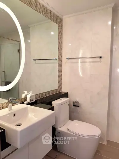 Modern bathroom with elegant fixtures and large mirror in a stylish real estate property.