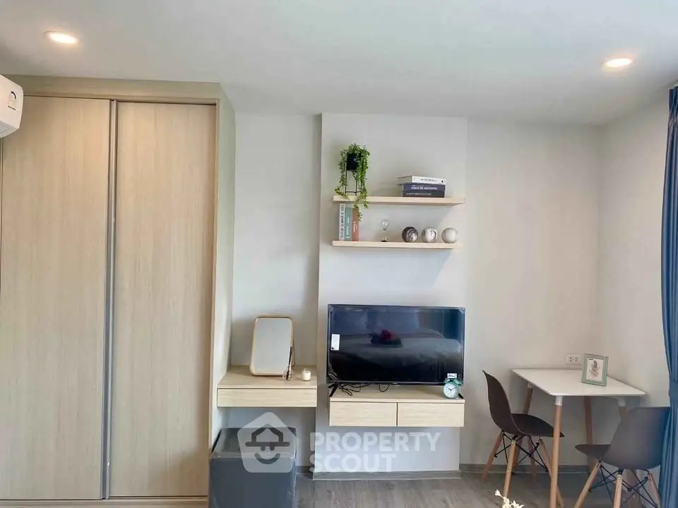 Modern living room with sleek TV setup and cozy dining area, perfect for urban living.