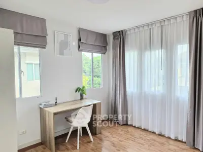 Bright study room with large windows and modern desk in a serene home setting.