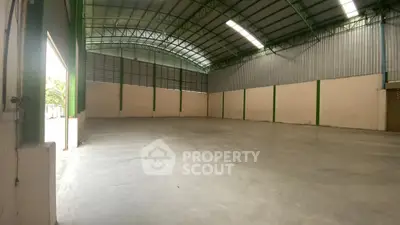 Spacious industrial warehouse with high ceilings and ample natural light.