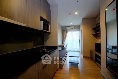 Modern apartment interior with sleek kitchen and cozy living area, featuring wood accents and natural light.