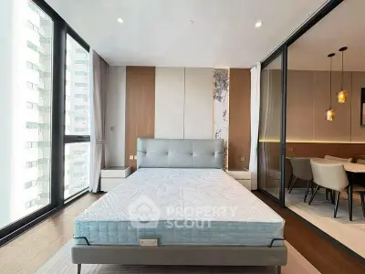 Modern bedroom with large windows and stylish dining area, perfect for urban living.