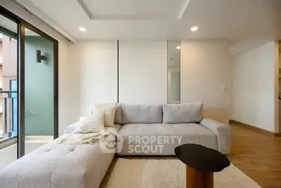 Modern living room with cozy sofa and balcony access in a stylish apartment.