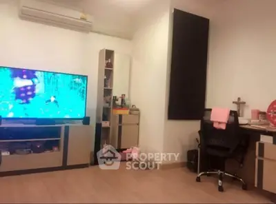 Cozy living room with modern TV setup and study desk, perfect for relaxation and work.