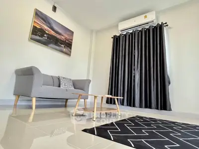 Modern living room with stylish sofa, chic rug, and air conditioning.