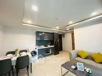 Modern open-layout kitchen and living area with sleek appliances and cozy dining setup.