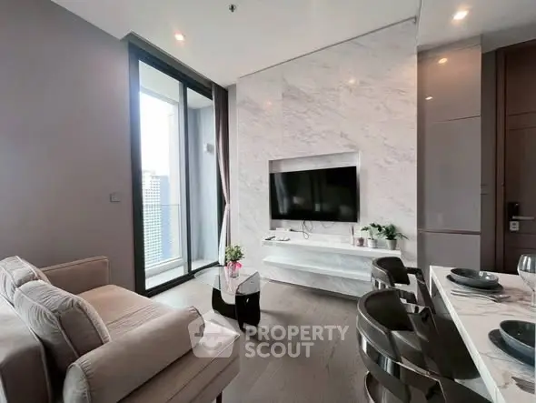 Modern living room with marble wall, large TV, and balcony view in luxury apartment.