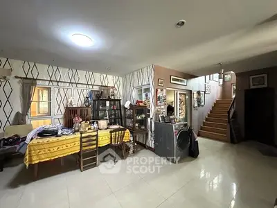 Spacious living area with modern decor and staircase, perfect for family gatherings.