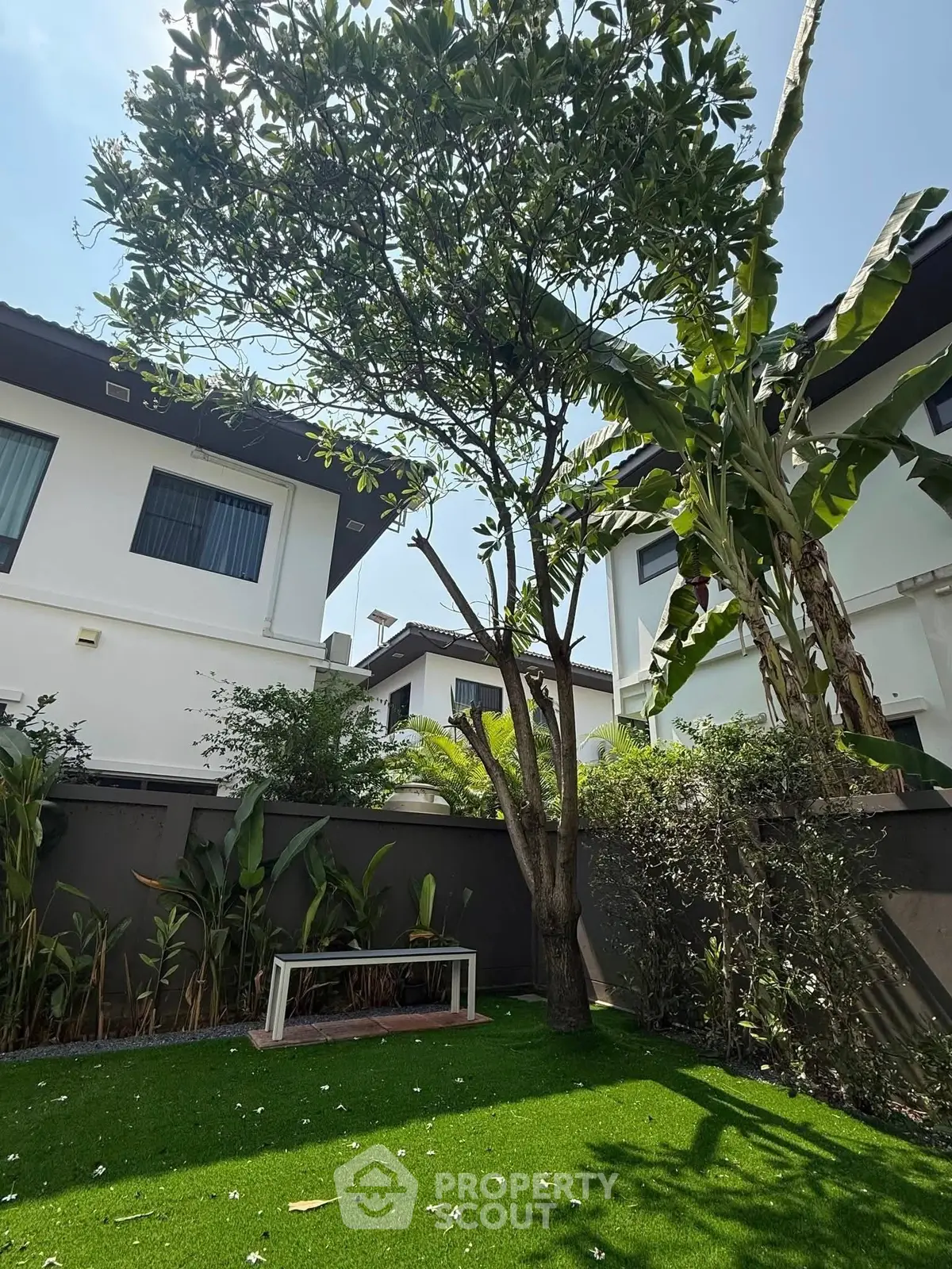 Charming garden view with lush greenery and modern house exterior, perfect for relaxation and outdoor enjoyment.