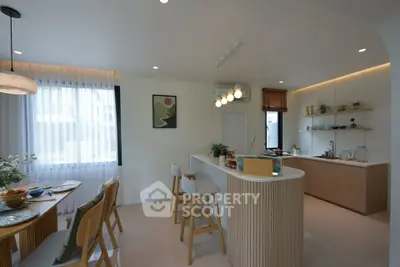Modern open-layout kitchen with stylish island and dining area, featuring contemporary lighting and decor.