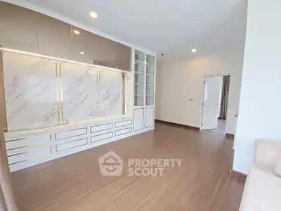 Spacious modern living room with elegant built-in storage and marble accents.