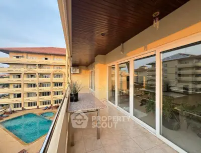 Spacious balcony with pool view in modern apartment complex