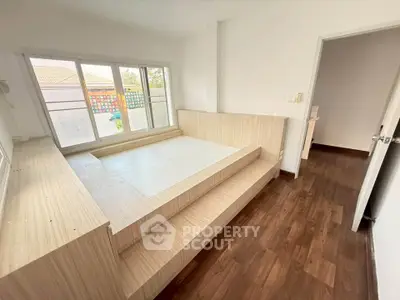 Modern bedroom with wooden platform bed and large windows