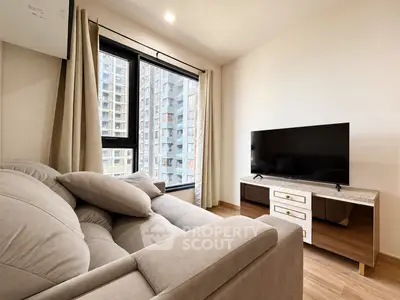 Modern living room with cozy sofa and large TV, featuring a city view from the window.