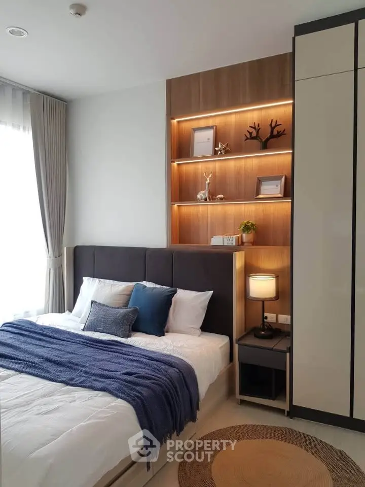 Modern bedroom with stylish decor and cozy lighting, featuring a comfortable bed and elegant shelving.