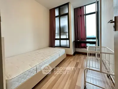 Modern minimalist bedroom with large windows and wooden flooring