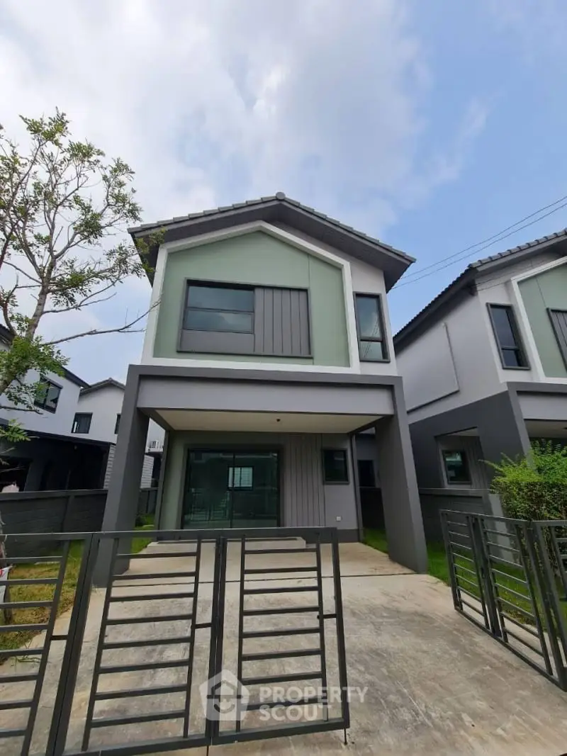 Modern two-story house with sleek design and spacious driveway in a suburban neighborhood.