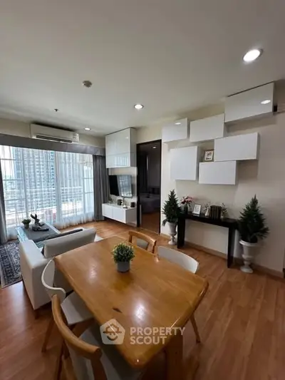 Spacious modern living room with wooden flooring and stylish decor in a high-rise apartment.