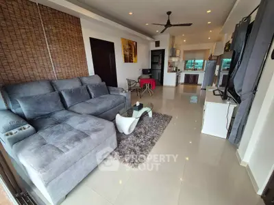 Spacious living room with modern decor and open kitchen layout, perfect for entertaining.