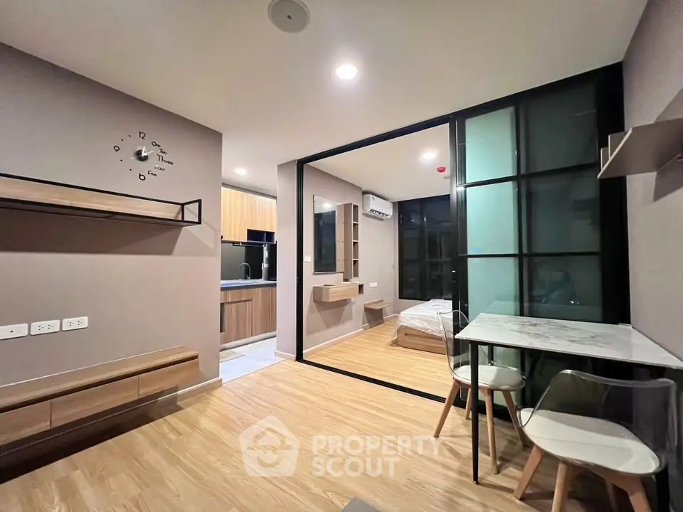 Modern open-plan living room with stylish kitchen and cozy bedroom in a contemporary apartment.