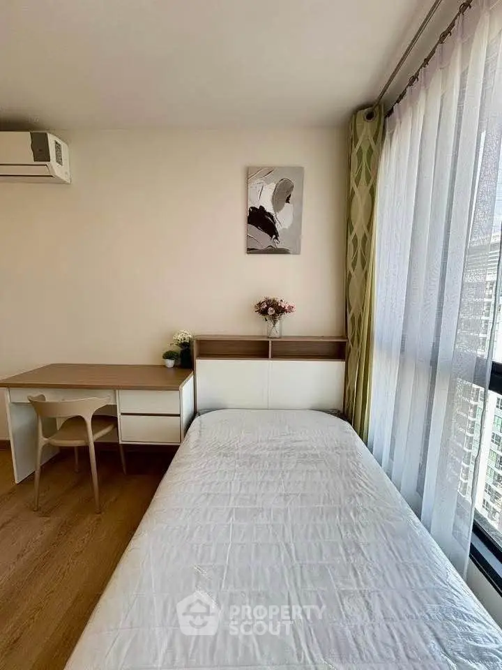 Cozy bedroom with modern decor and city view, perfect for urban living.