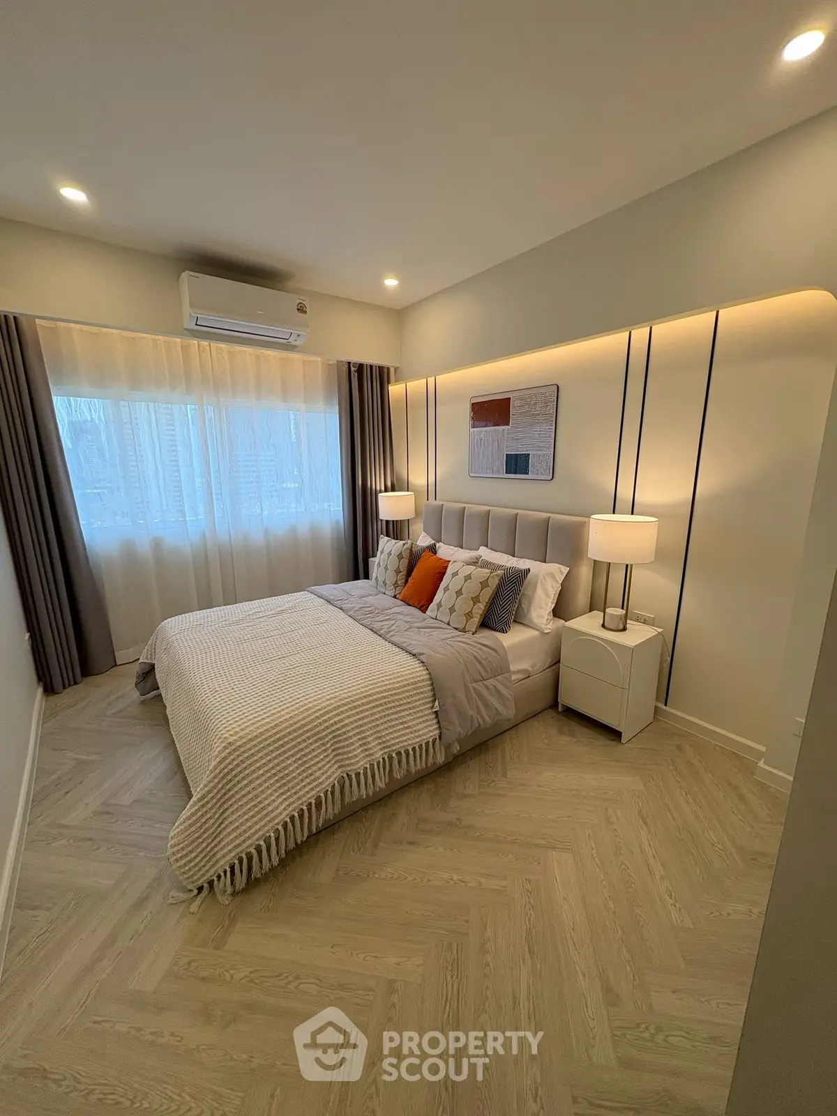 Modern bedroom with stylish decor and natural light, featuring a cozy bed and elegant lighting.