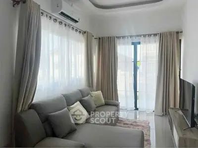 Bright and cozy living room with modern gray sofa and large windows.