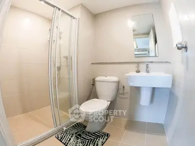 Modern bathroom with shower enclosure and sleek fixtures in a contemporary apartment.