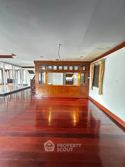 Spacious living room with polished wooden floors and built-in wooden cabinetry.