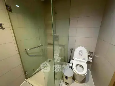 Modern bathroom with glass shower and smart toilet in sleek design.