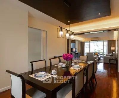 Elegant dining area with modern lighting and spacious living room view.