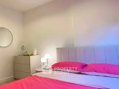 Modern bedroom with stylish decor and vibrant pink bedding, perfect for a cozy and inviting atmosphere.