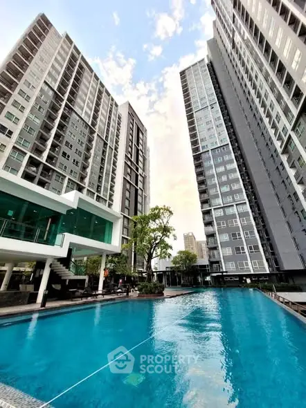 Luxurious high-rise apartment complex with stunning pool and modern architecture.