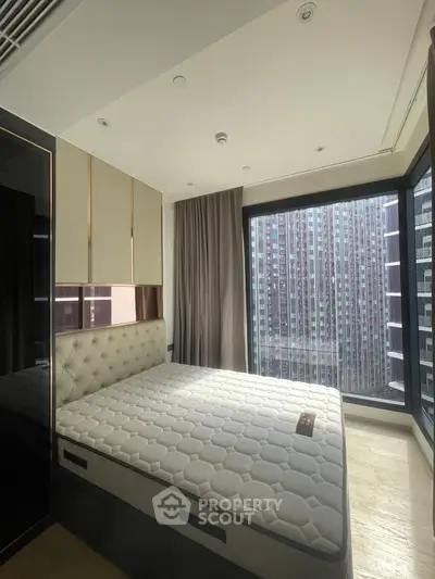 Luxurious bedroom with panoramic city view and modern furnishings.