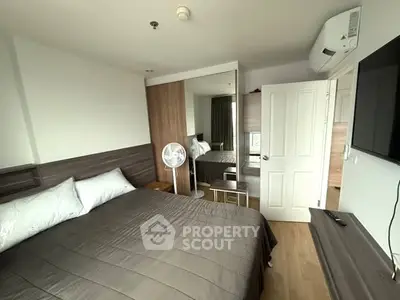 Modern bedroom with sleek design, featuring a comfortable bed, mirrored wardrobe, and wall-mounted TV.