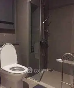 Modern bathroom with glass shower and sleek fixtures in contemporary apartment.