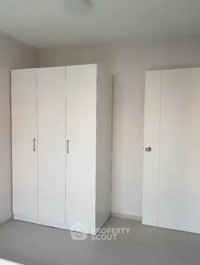 Minimalist white wardrobe in a modern bedroom with sleek design